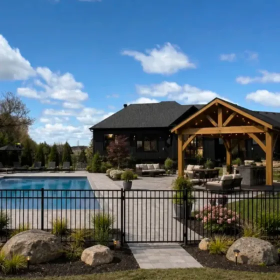Timber pavilion and pool with stone patio and planted beds
