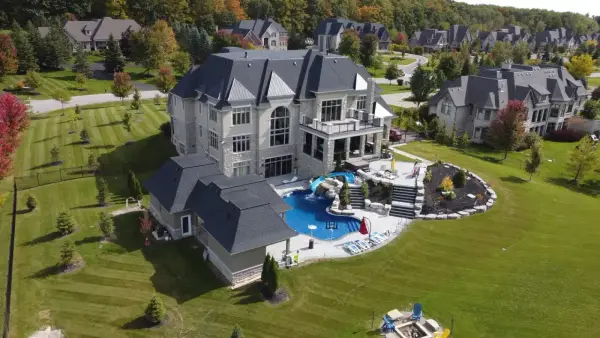 Aerial of the stone estate and resort-style backyard