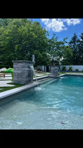 Stone water feature spilling into the pool