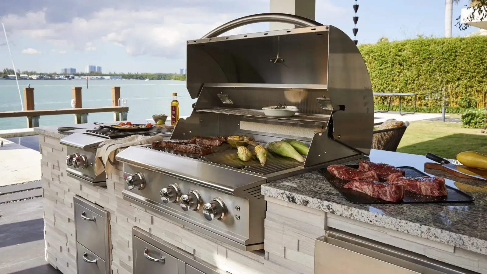 Built-in grill cooking on a patio above the water