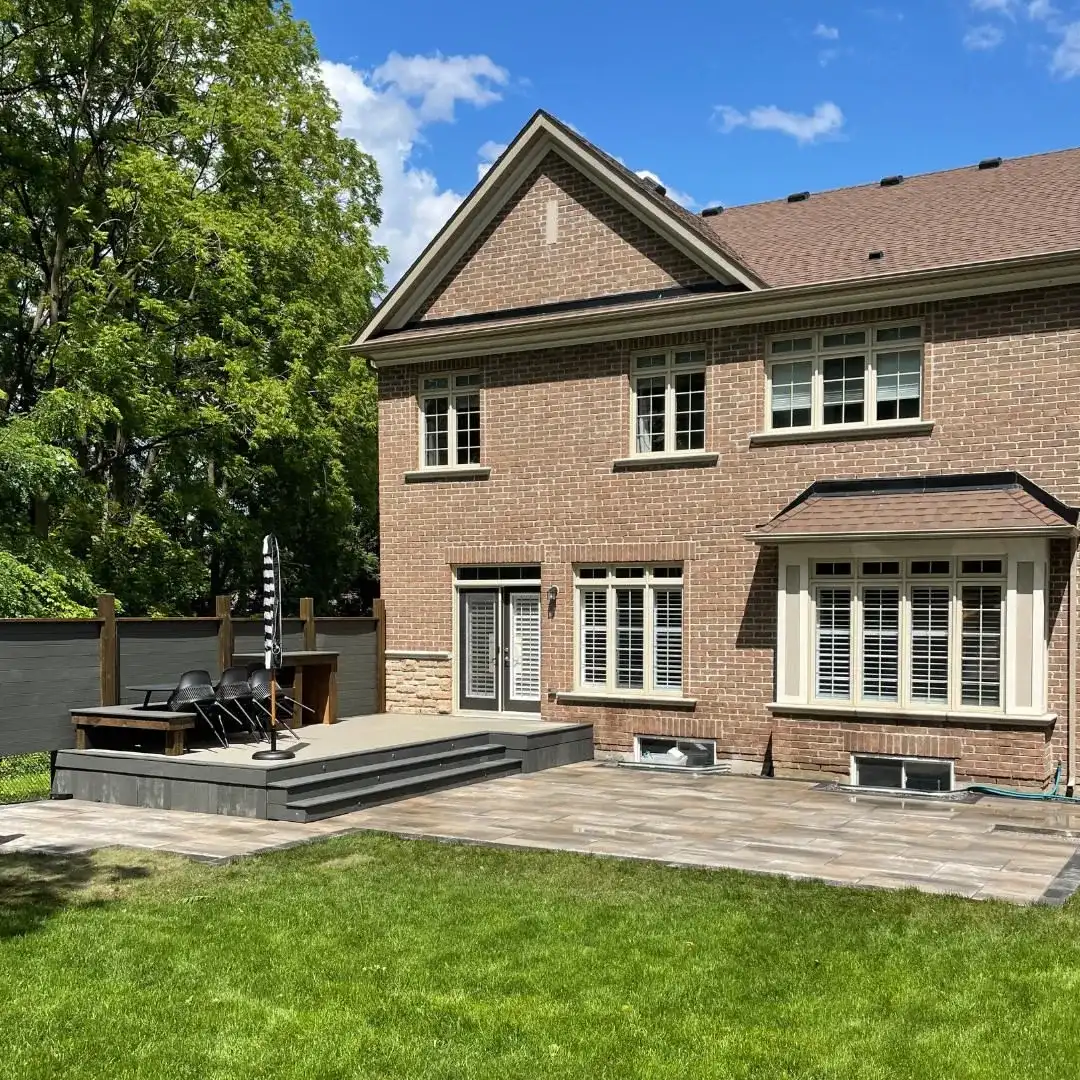 Paver patio with a stone water feature and lawn