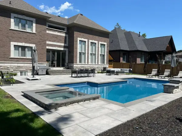 Rectangular pool with a raised spa beside the house