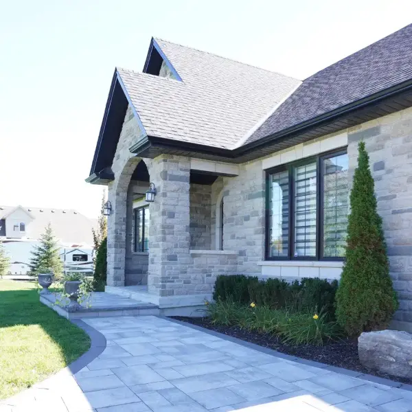 Stone walkway and plantings at a stone-clad home